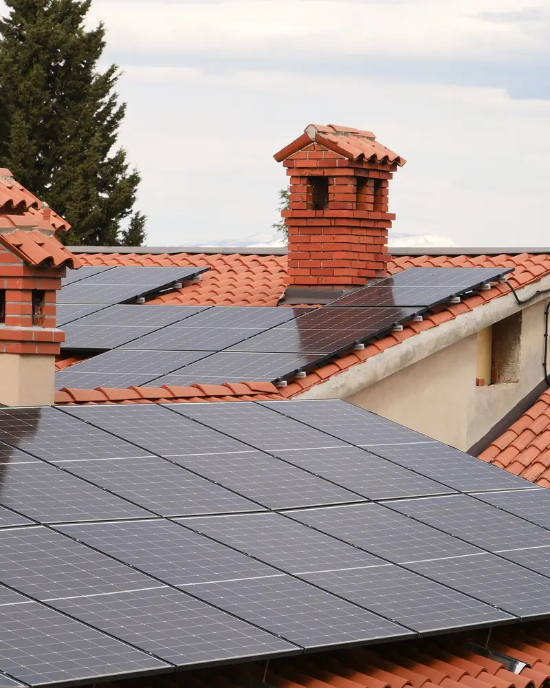 Moduli fotovoltaici su tetti in coppi, tra comignoli in mattoni