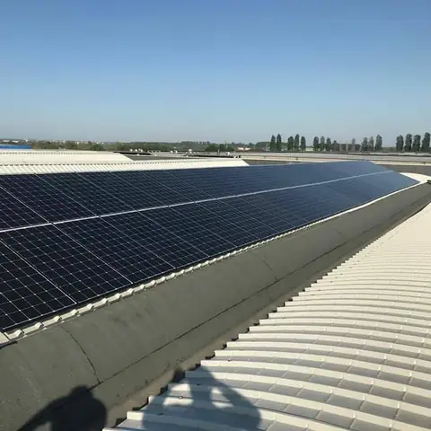 Lunga fila di moduli su una copertura curva bianca sotto il cielo terso