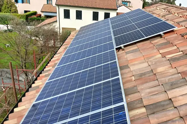 Moduli fotovoltaici su un tetto in coppi, tra le case del paese